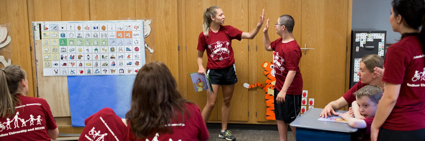 Student volunteering at Camp Connections and is give a high five to one of the participants. 
