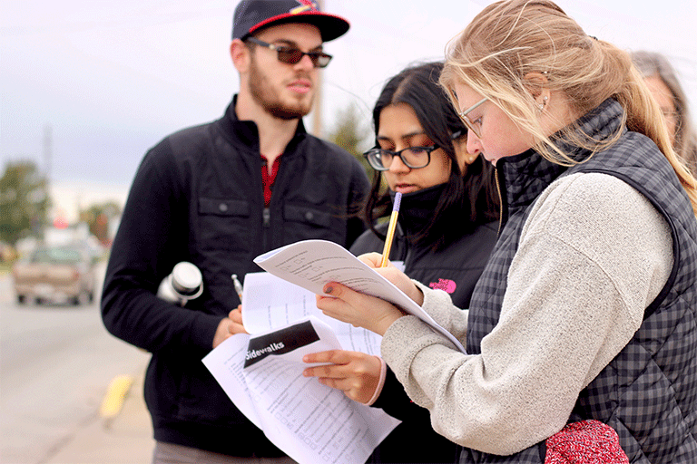 Three students conducting survey. 
