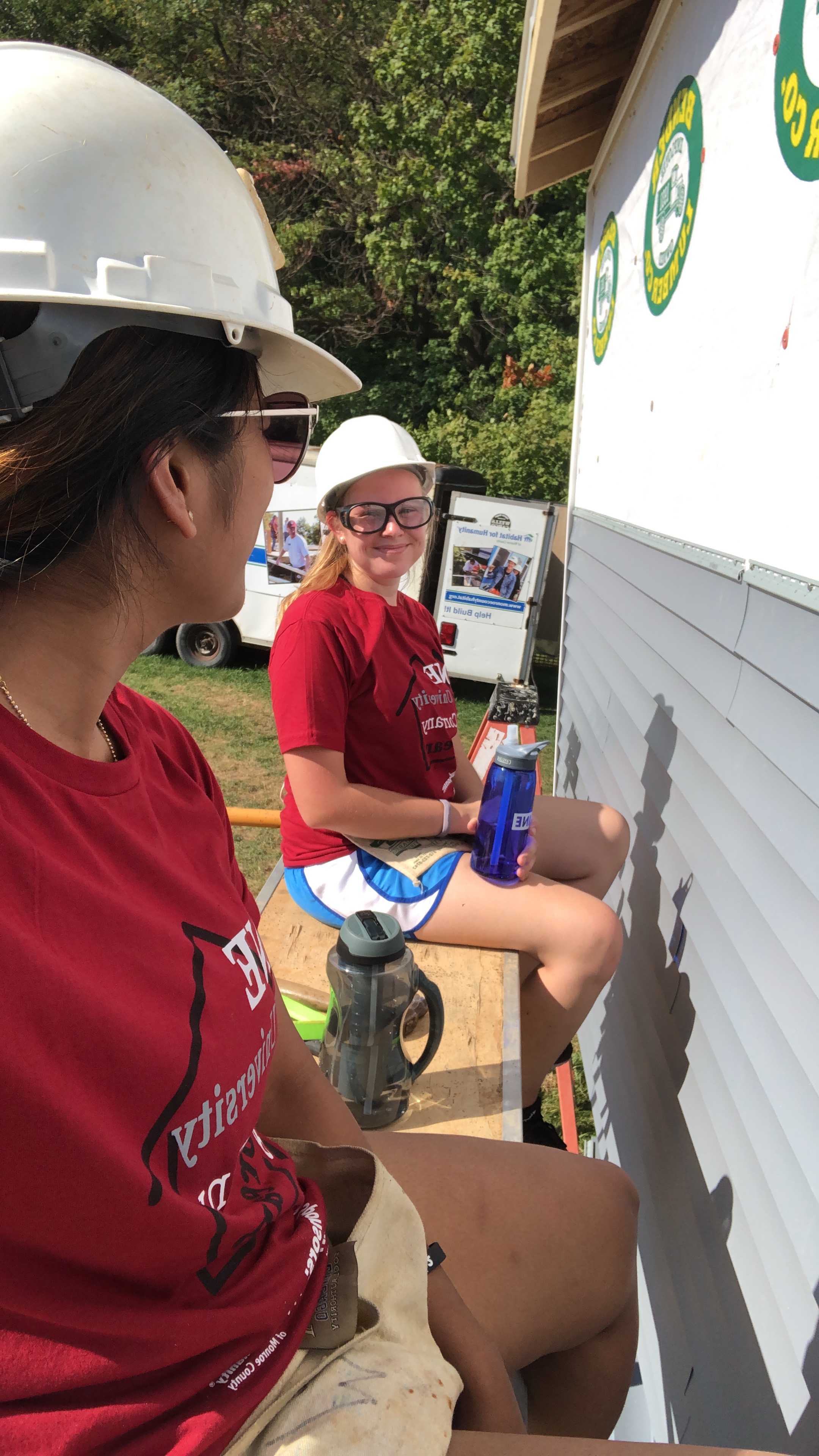 Dakota Suomela, Treasurer of Leadership Corps and VP of Volunteer Corps, and a peer volunteering with Habitat for Humanity. 