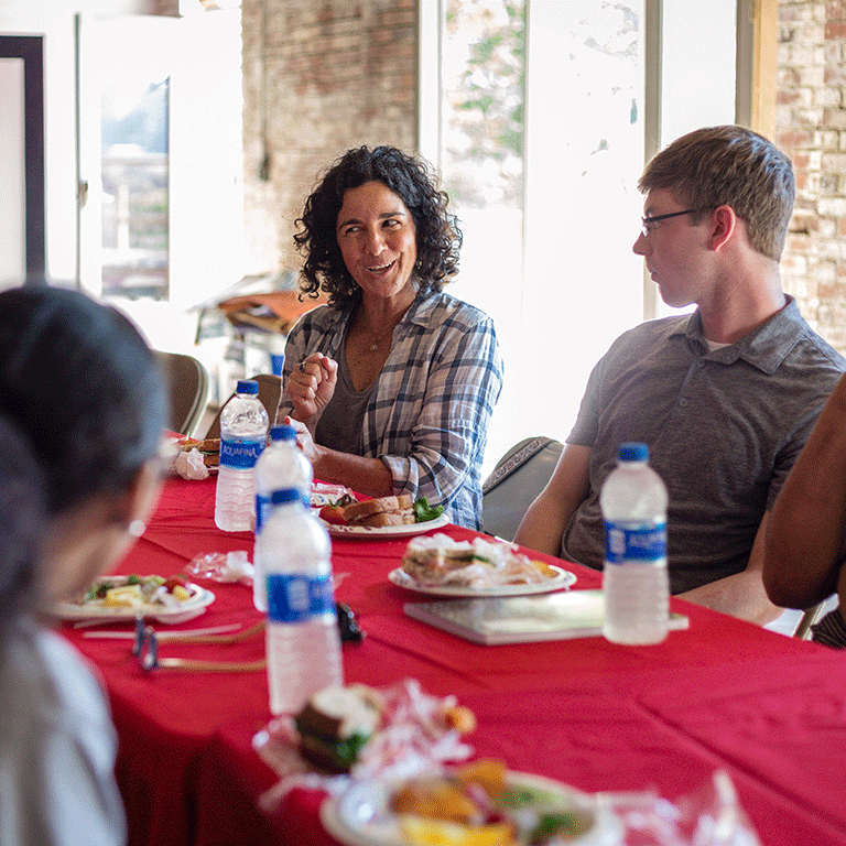 Student and faculty engaging in service learning conversation.