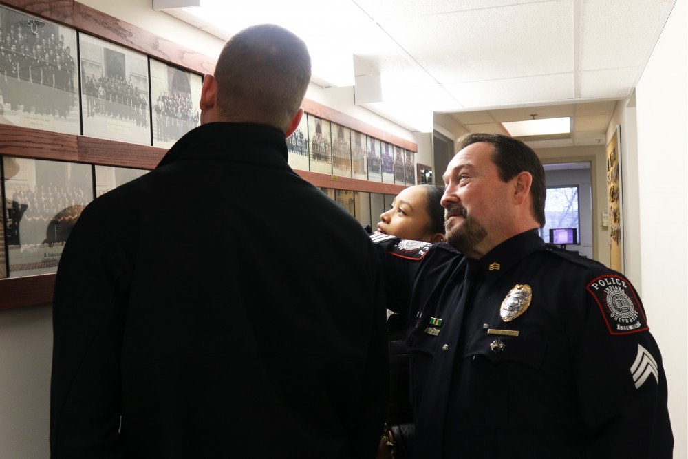 IU Police Department Sgt. James Snyder shows cadets Jasmyn Bell and Patrick Hash the photo from his own commissioning ceremony upon graduation from the IUPD Cadet Program in 1987.