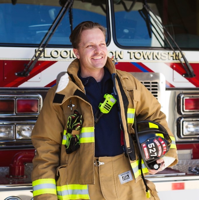 David McDonald stands in front of a firetruck.