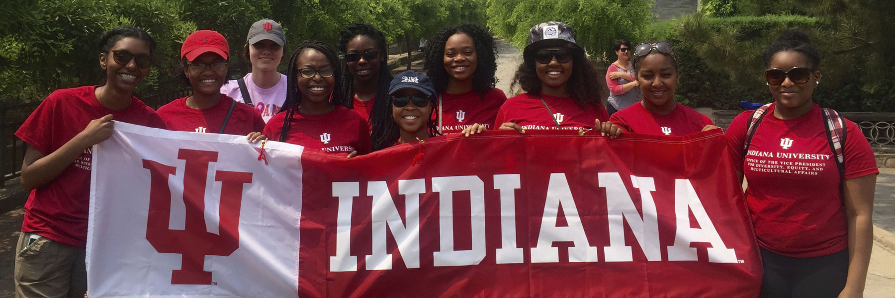 IU students studying abroad and holding an IU flag.